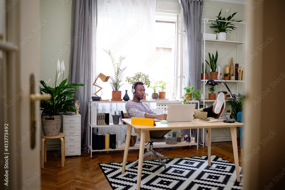 Relaxed man using laptop at home office Relaxed man using laptop at home office