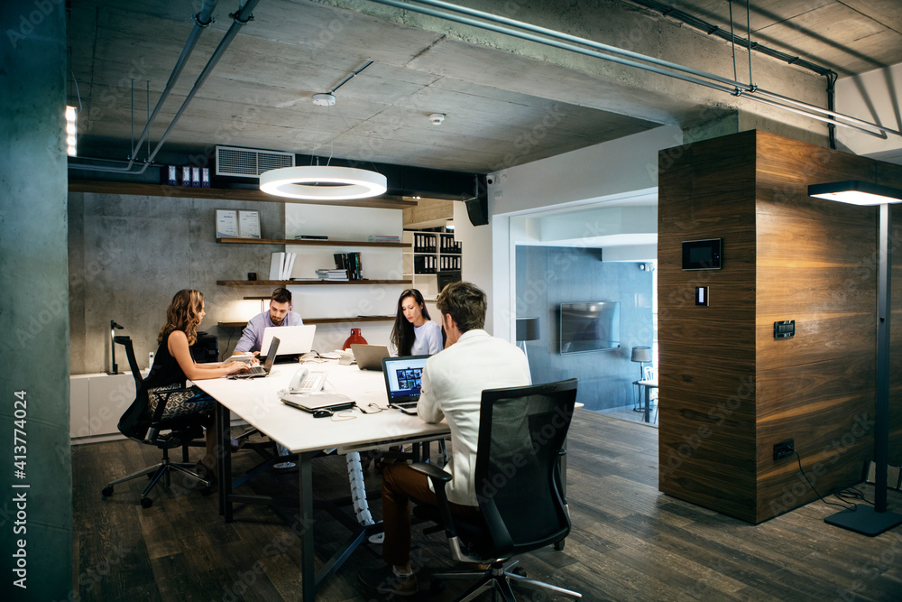 Business people using laptops while working in office Business people using laptops while working in office