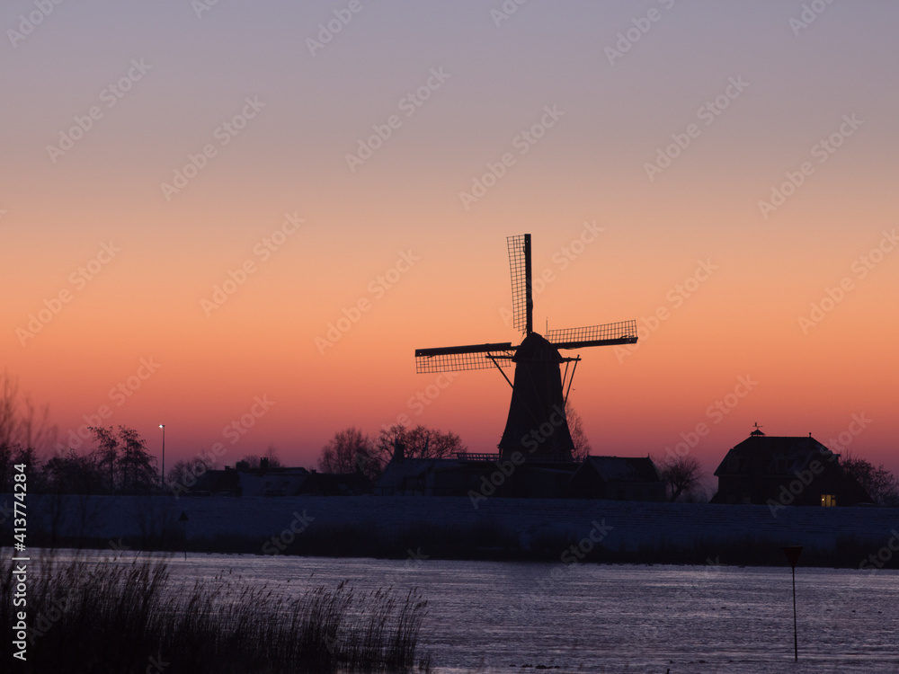 A dutch windmill silhouette in the early morning