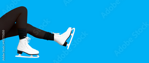 Female feet in skates isolated on blue panoramic background. Winter time, ice skating, skater. Girl, winter sports, copy space