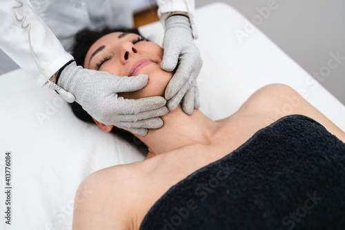 Fototapet Micro sensory electrical BIO EMS micro-current treatment for face and body electrode stimulation with conductive gloves