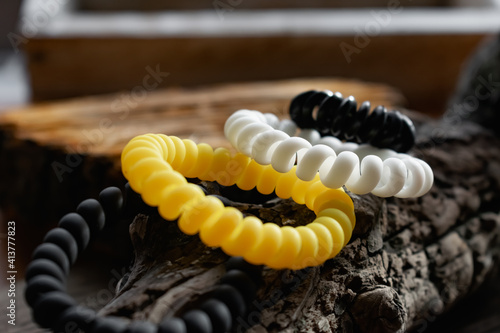 Fashionable and modern elastic hair springs. Different colors of stretching hand bracelets on wooden background, stand