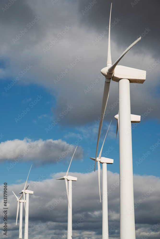 Low angle view of wind turbines against cloudy sky Low angle view of wind turbines against cloudy sky