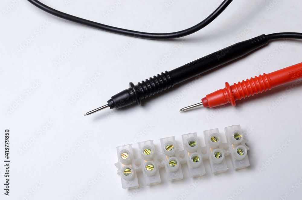 multimeter probes and terminal blocks lie on a light background. close-up. multimeter probes and terminal blocks lie on a light background. close-up.
