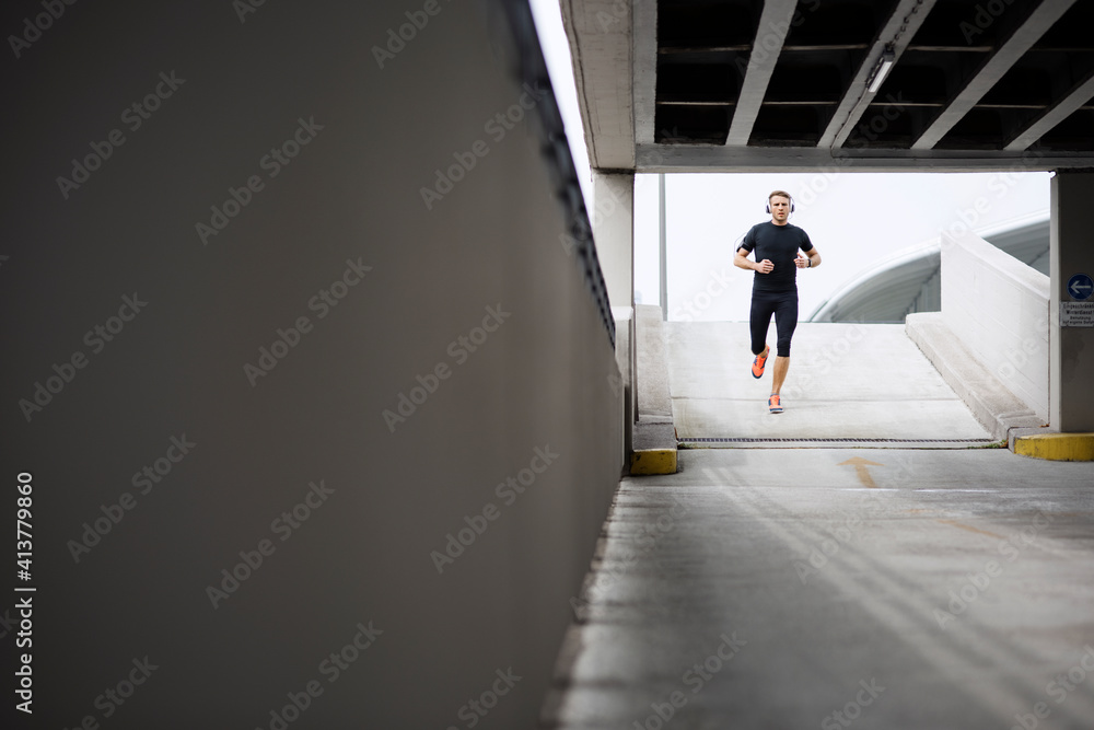 Determined young man running in parking lot Determined young man running in parking lot