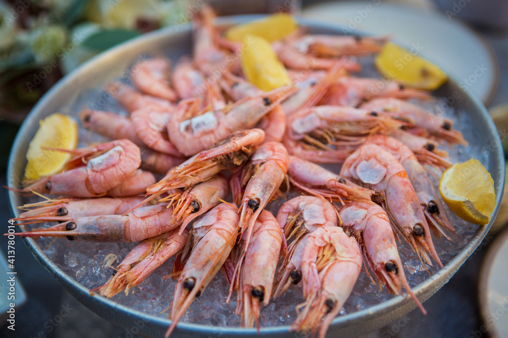 shrimp in ice with lemon on a table in a restaurant shrimp in ice with lemon on a table in a restaurant