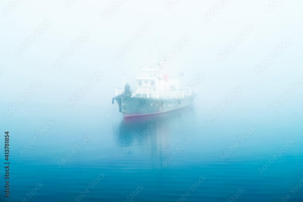 Ship floats on a foggy sea in the morning, dawn. Captain at the bow of the ship