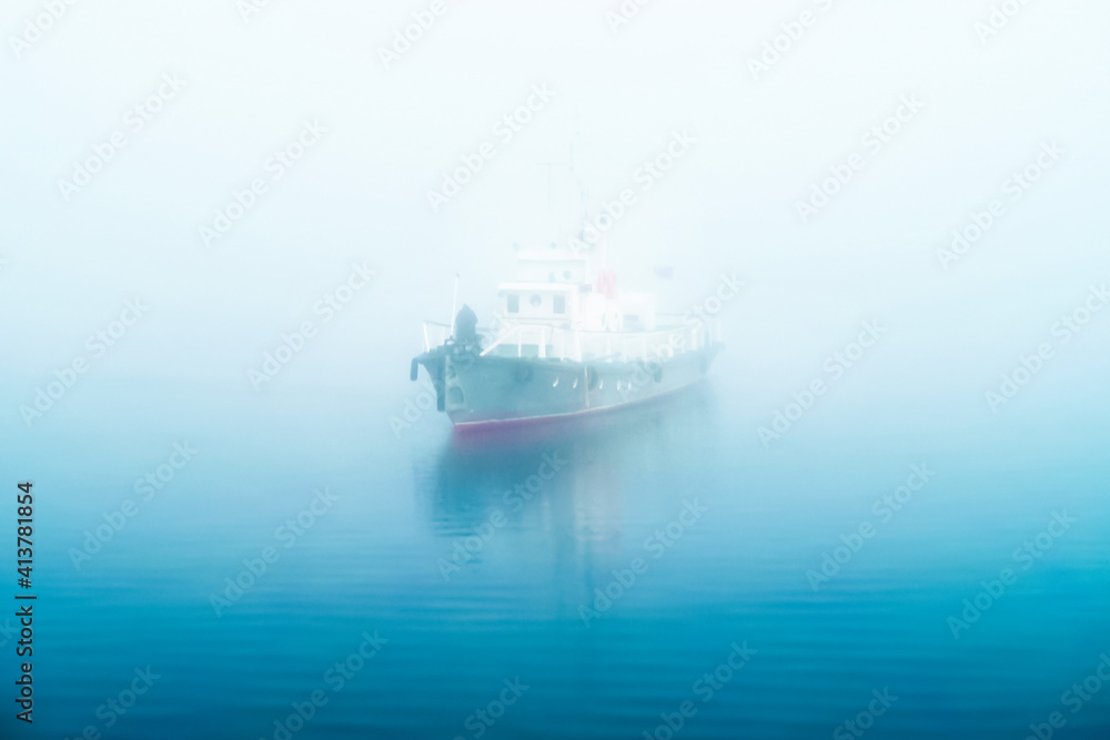 Ship floats on a foggy sea in the morning, dawn. Captain at the bow of the ship Ship floats on a foggy sea in the morning, dawn. Captain at the bow of the ship