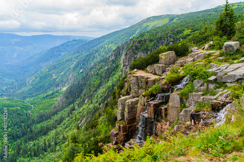 high waterfall with a beautiful landscape of the mountains in the Czech Republic
