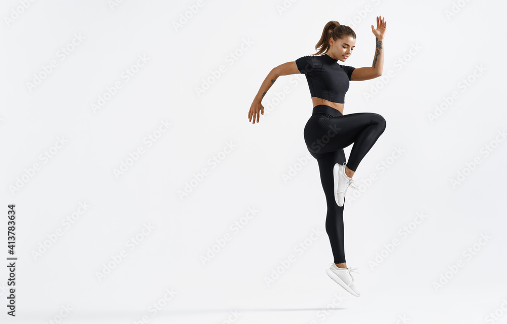 Fit woman exercising indoors. Healthy young female athlete doing fitness  workout. Sportswoman in sport clothing jumping on white background,  training muscles before running Stock Photo | Adobe Stock