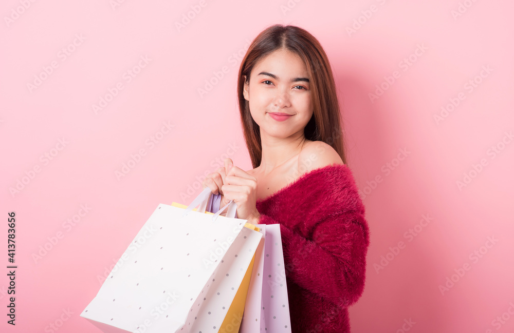 Cheerful Beautiful Young Woman in a Pretty mini dress with Shopping bags on pink background. Lifestyle and Summer Fashion. Shoping and Fashion. Winter fashion