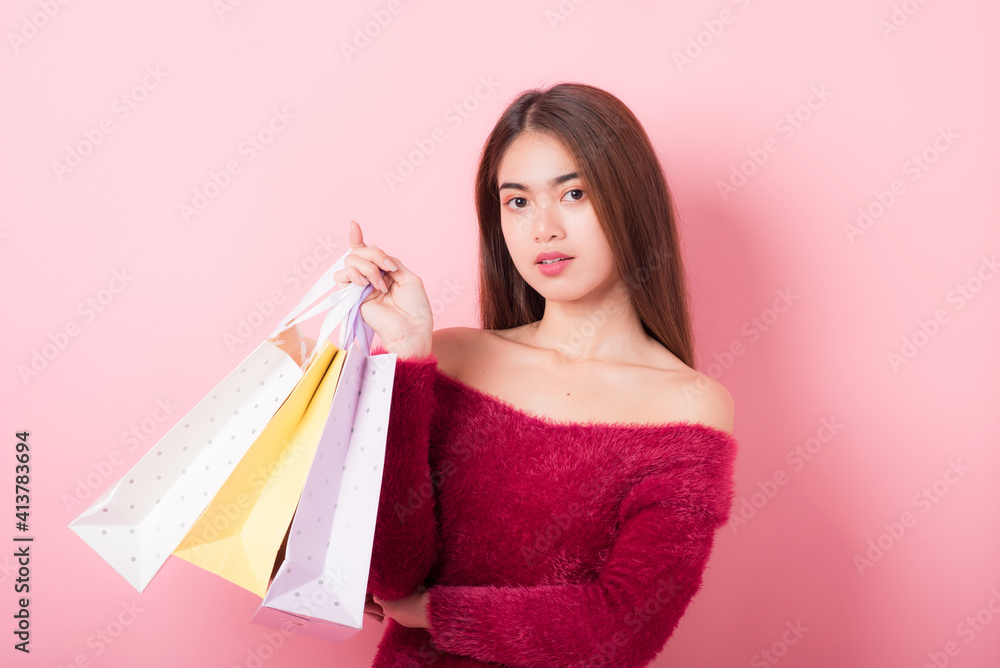 Cheerful Beautiful Young Woman in a Pretty mini dress with Shopping bags on pink background. Lifestyle and Summer Fashion. Shoping and Fashion. Winter fashion