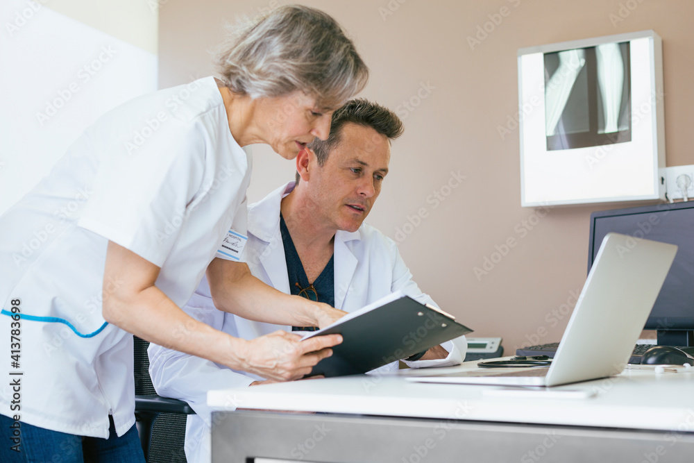 Doctors working at table in hospital Doctors working at table in hospital