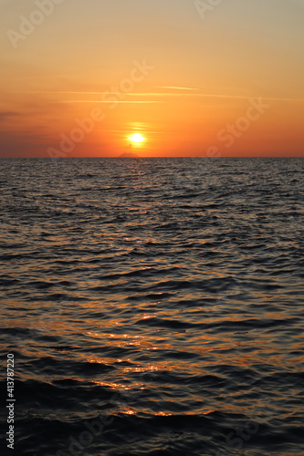 Seascape orange sunset and silhouette of Stromboli volcano in the haze on the horizon  Calabria  Italy