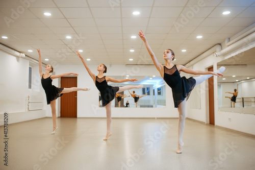 Three young ballerinas, teens rehearsing in class