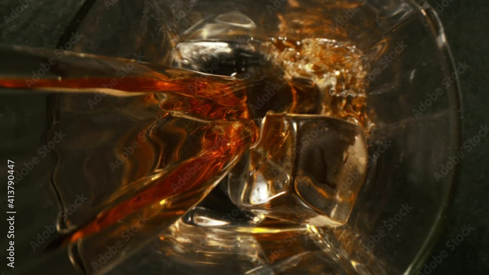Super slow motion of pouring whiskey or rum with camera motion. Filmed on high speed cinema camera, 1000 fps. Super slow motion of pouring whiskey or rum with camera motion. Filmed on high speed cinema camera, 1000 fps.