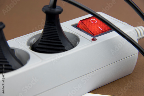Connected electrical devices in an extension cord on a brown background