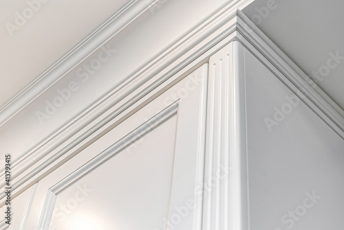 Classical style white wardrobe closeup view. Details classical furniture