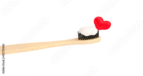Bamboo toothbrush and toothpaste with red heart on white isolated background. Dentistry and healthcare. Disease of teeth and gums, bleeding gums, blood. top view. copy space for text