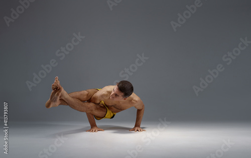 Male yoga in a difficult pose on hands, meditation