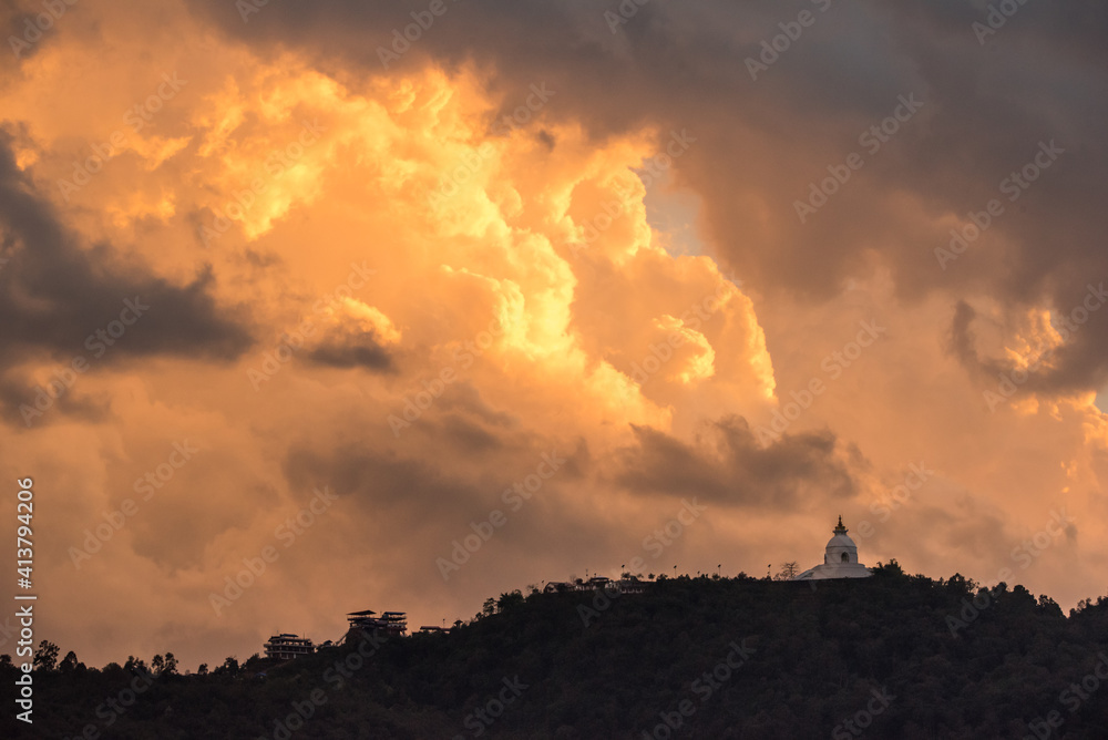 Colorful Sunset over Peace Pagoda in Clouds on Mountain, Pokhara Nepal Colorful Sunset over Peace Pagoda in Clouds on Mountain, Pokhara Nepal
