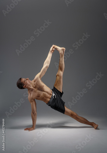 Athletic yoga doing stretching exercise in studio