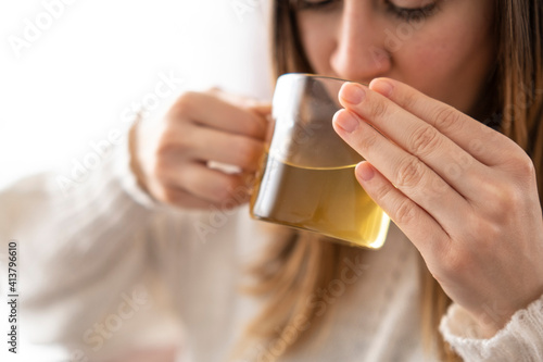 Woman drinking green tea from transparent mug in the morning.Healty lifestyle,relaxing time in white background.