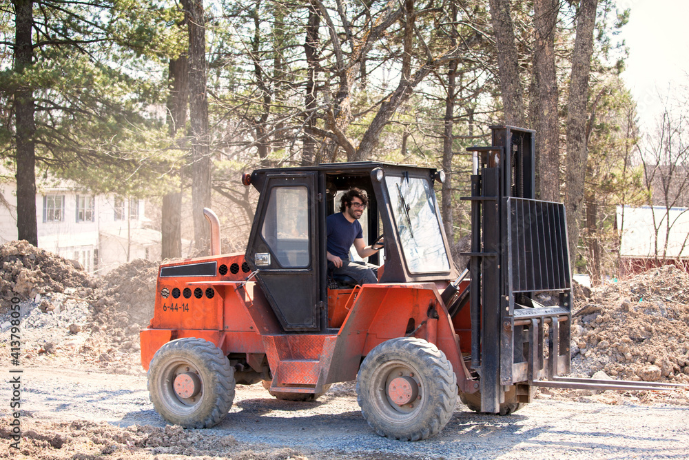 Man driving forklift on gravel road Man driving forklift on gravel road