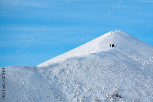 Sihouettes of a group of skiers from afar on Vallières mountains ridge, Gaspesie, Quebec, Canada