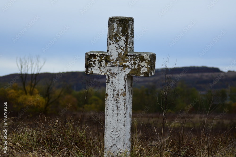 Old cross on the side of a road, with white paint flaking off