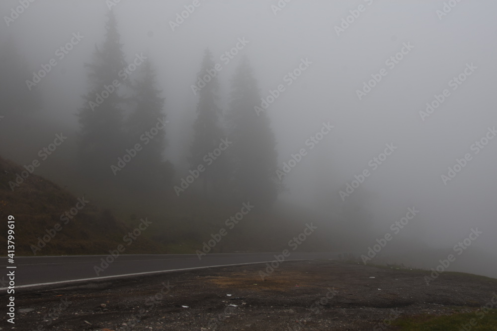 Mountains road under thick fog