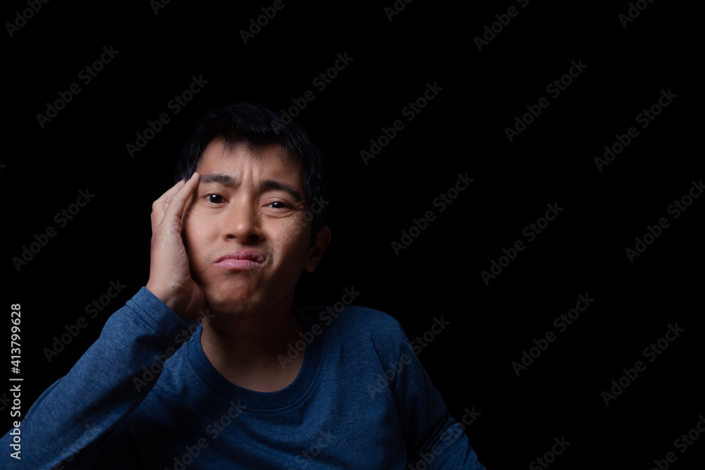 Asian man getting bore something on black background.