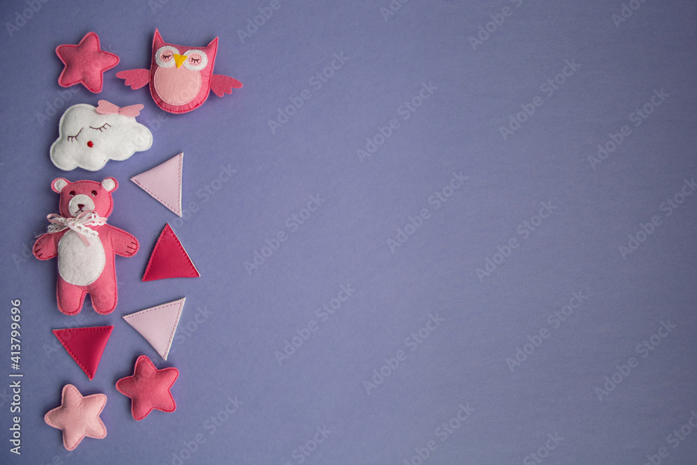Fototapeta premium knitted toys cloud, star, bear, ram, owl, bird pink and blue colors lie on a purple background