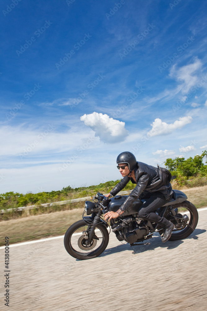 Man riding motorcycle on road against cloudy sky Man riding motorcycle on road against cloudy sky