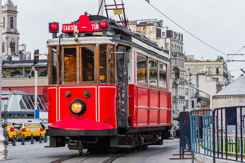 Nostalgic red tram in Taksim Square. Istiklal Street is a popular touristic destination in Istanbul, Turkey.  . - obrazy, fototapety, plakaty 