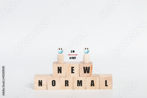 New normal with wooden block cubes and Social distancing by using wooden doll.