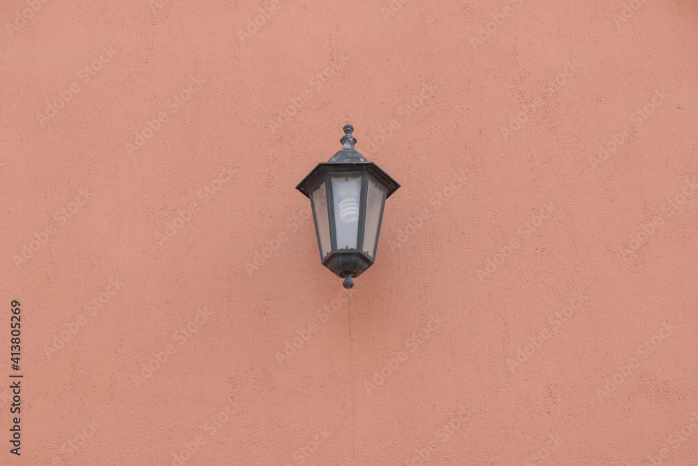 Old lantern with a white lamp. Wall color - Oriental Pink, Hue Red. Vintage lantern concept.