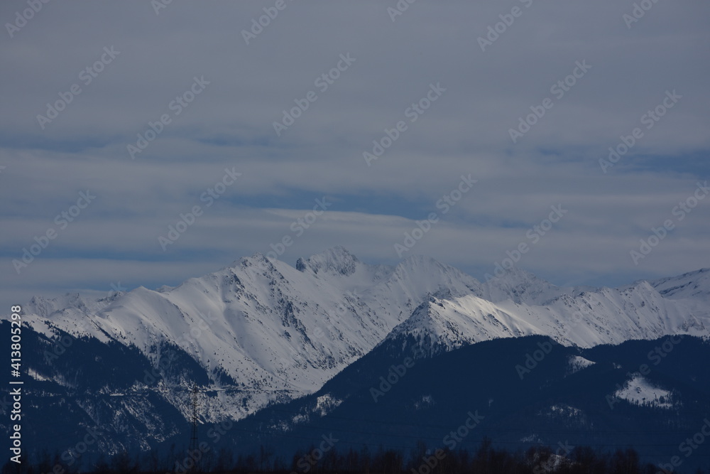 Snow covered mountains with forest in the foreground
