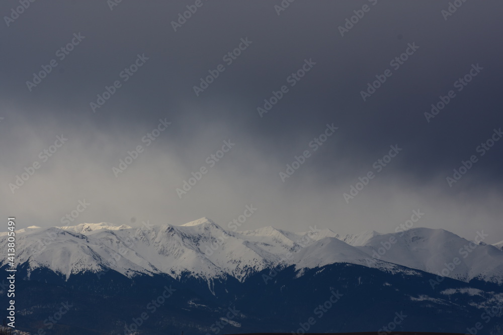 Snowy mountains peaks with dark sky