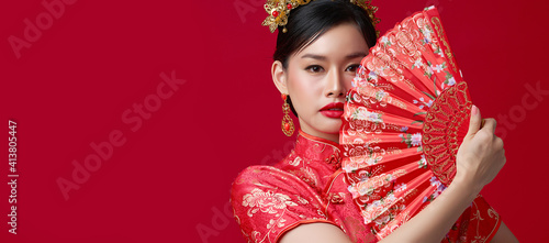 Asian chinese woman in traditional dress on red background. Chinese new year festival.