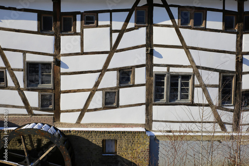 View on isolated half timbered facade with paddle wheel of old water mill - Wegberg, tuschenbroich, Germany photo