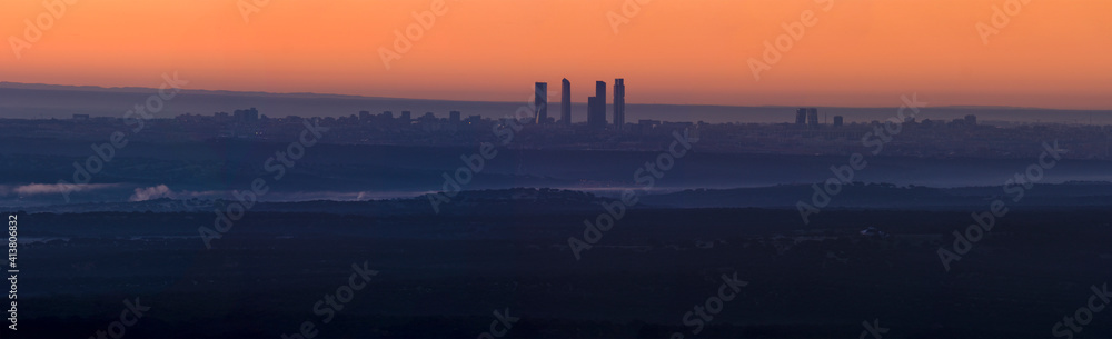 Panorámica de amanecer cuatro torres de Madrid con cielo naranja