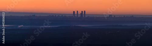 Panorámica de amanecer cuatro torres de Madrid con cielo naranja