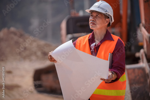 Male engineer looks to Pimm Kheaw to plan work for road construction, transportation development concept. photo