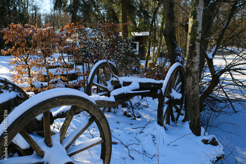 View on wheels of old wooden cart on german farm with snow - Wegberg, Germany photo