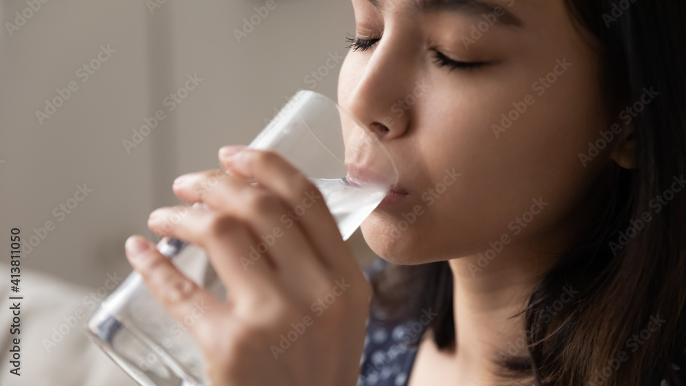 Cropped view of happy asian woman quenching thirst drinking cool clear potable water without gas. Close up of delighted young lady face enjoying taste of natural still aqua taking care of health skin Cropped view of happy asian woman quenching thirst drinking cool clear potable water without gas. Close up of delighted young lady face enjoying taste of natural still aqua taking care of health skin