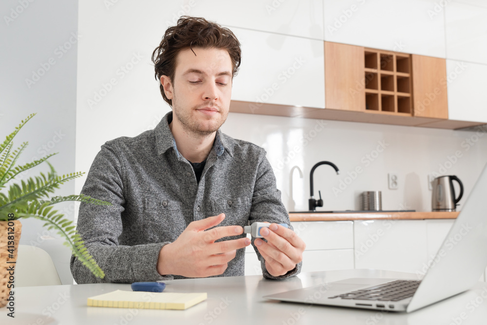 Young man measures blood sugar level