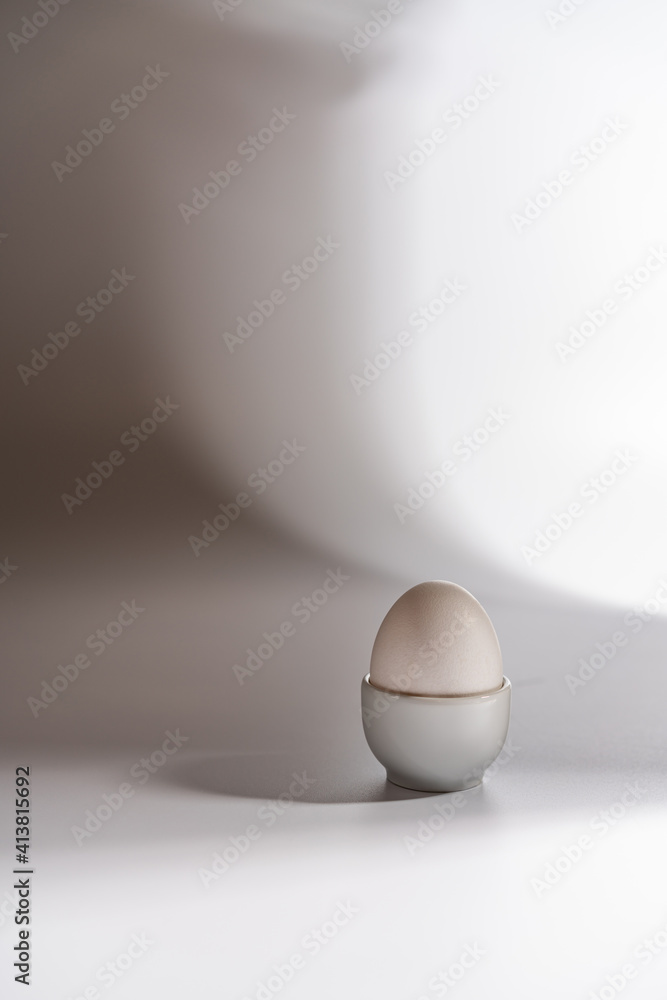 White egg on a white background with bright shadows White egg on a white background with bright shadows