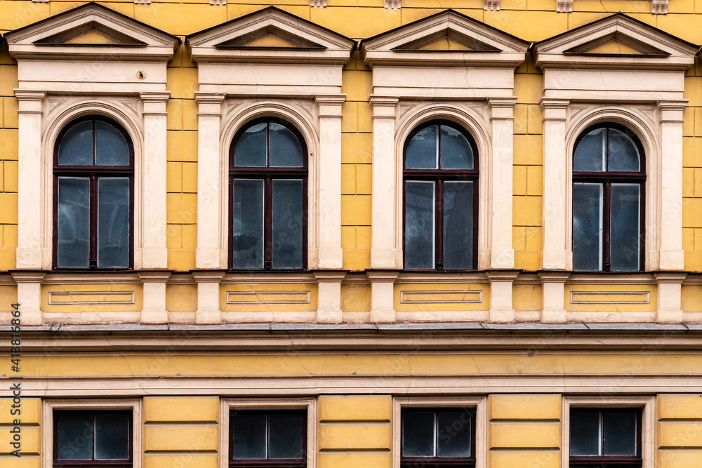 Detail of yellow art nouveau building façade of four windows at renovation needed building in Riga, Latvia, Europe