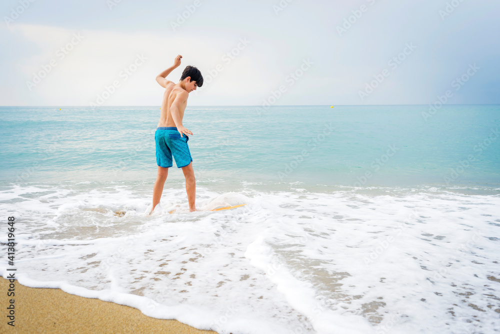Young teen surfing on seashore in sunny day Young teen surfing on seashore in sunny day